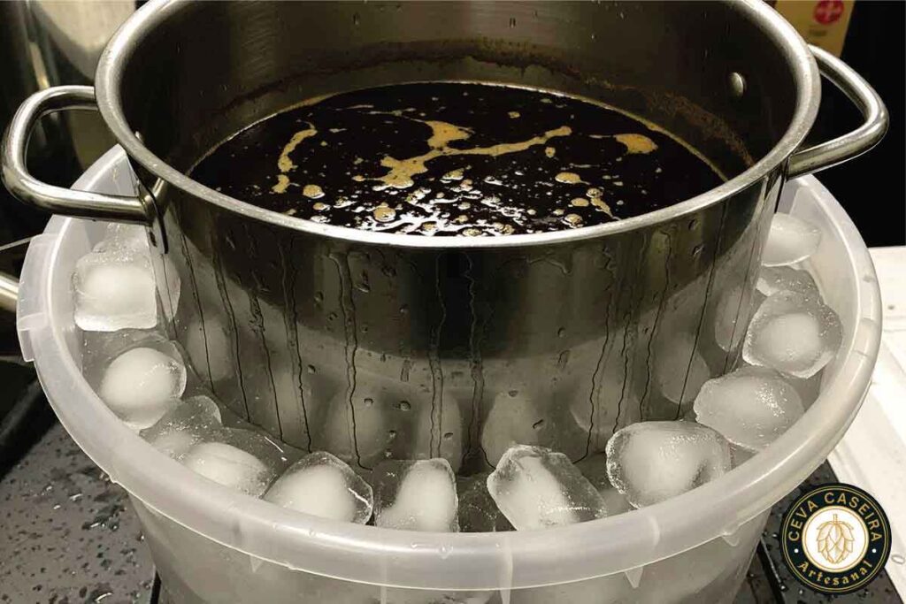 Resfriamento do mosto da cerveja artesanal. Panela imersa no balde com gelo.