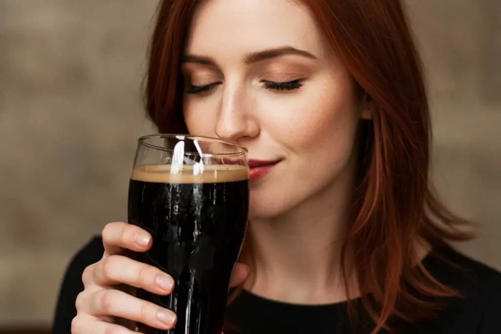 Mulher degustando com o olfato, uma stout artesanal.